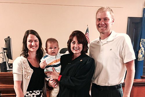 Happy adoptive family with the judge at their son's adoption finalization