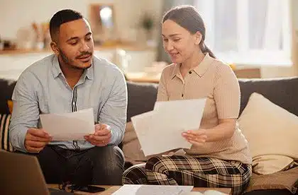 Young couple working on their finances in living room