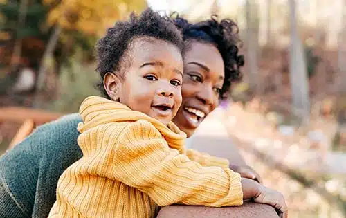 Newly-adopted toddler having fun with mom in the park
