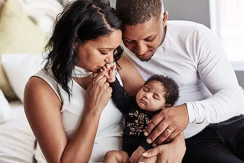 affectionate young family bonding with their baby girl at home