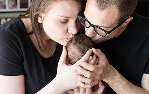 Lifetime adoptive parents Chris and Rianna kiss their newborn baby