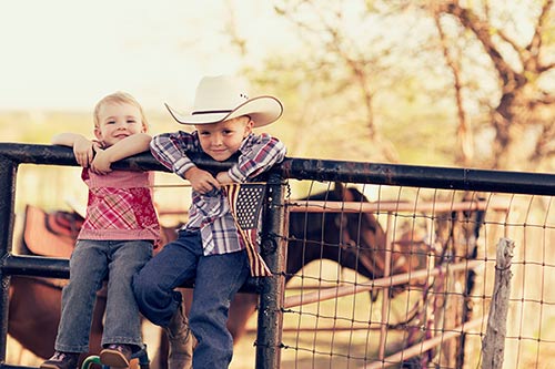 Two children who were adopted by Texas adoption laws visit the horse pen