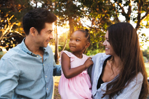 Multi-racial family with adopted child spending time together at the park