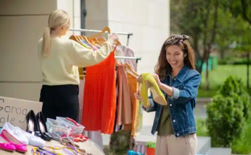Excited woman looking at shoes she found at a garage sale for adoption