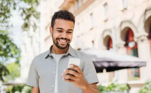 Handsome young man using smart phone in a city