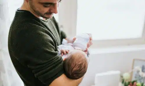 Adoptive dad feeding his baby boy a bottle