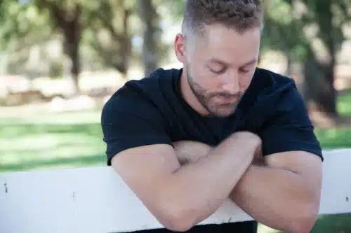 Young man leans on a fence