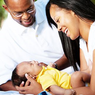 African American adoptive family holding their adopted baby