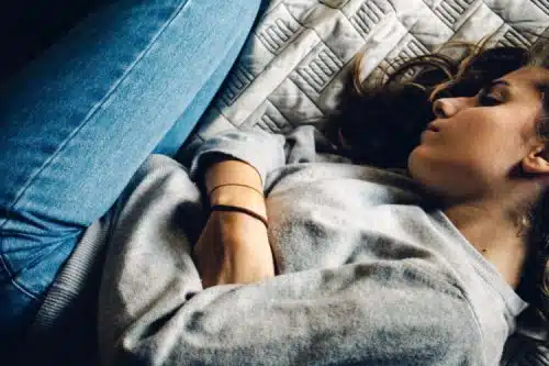 Woman suffering from birth mother grief, lying on her bed