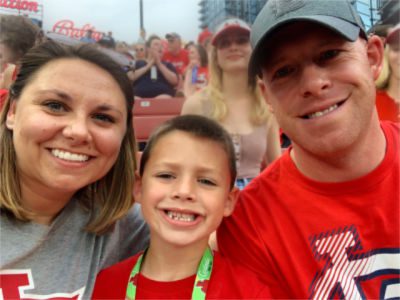 Rikki and Bryan with their son at a Cards game