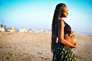Pregnant woman in LA standing on the beach