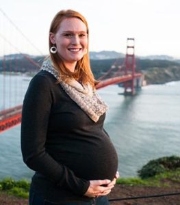 Pregnant woman holding her belly near the Golden Gate Bridge