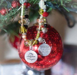 Adoption prayer bracelets, one of the best birth mother gift ideas, hanging in a Christmas tree