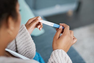 Woman looking at positive pregnancy test in Raleigh North Carolina