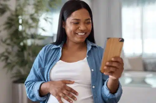 Black pregnant woman happy to be meeting adoptive parents over the phone