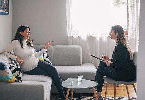 A pregnant woman receives pre adoption counseling in a therapist's office