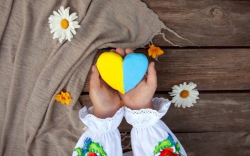 Ukrainian child's hands hold a yellow and blue heart