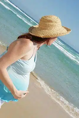 Pregnant woman looking out at the ocean in Pensacola