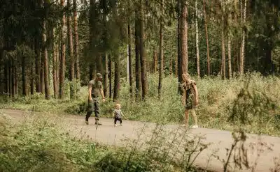 Young military family walking in a pine forest
