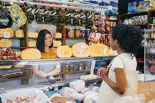 Deli employee serving a pregnant customer her order