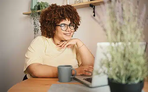 Tori writes on her laptop at her home office about why she chose adoption
