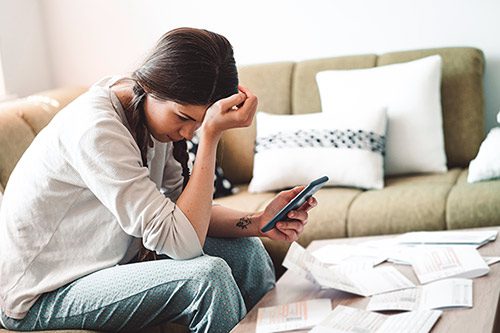 Young woman struggling to pay her bills and wondering about the cost of adoption 