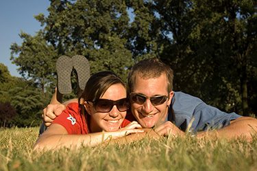 couple laying on grass smiling