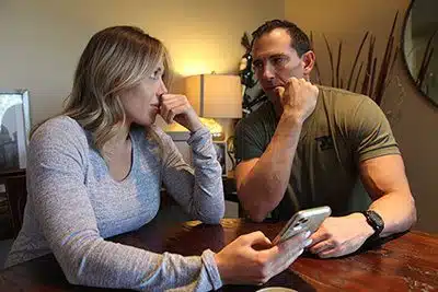 An adoptive couple arguing over a text from a potential birth mother