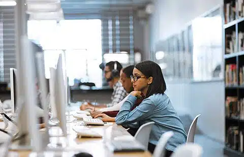 Pregnant student working on a research paper in a campus computer lab