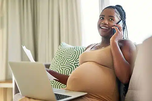 Young expectant mother calls an adoption agency while looking at their website