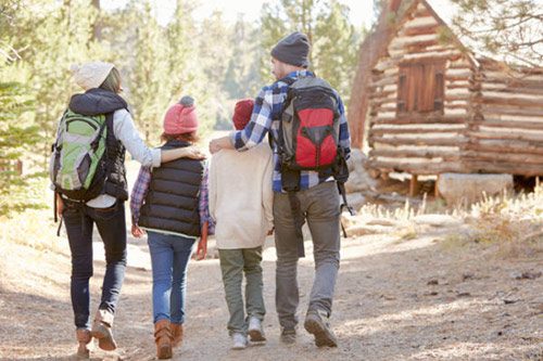 Family of four heading out for a hike while camping