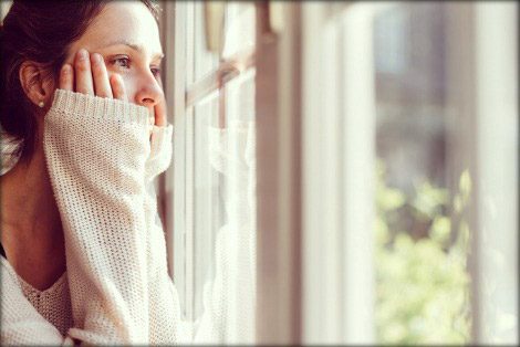 Young woman gazing out a window thoughtfully
