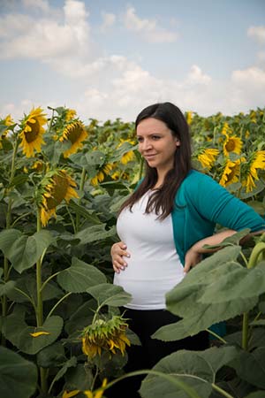 pregnant woman standing in a sunflower field in North Dakota