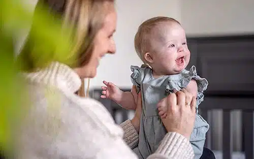 A mother playing with her baby in the nursery