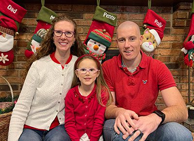 Carolyn and JP pose for a Christmastime photo with their daughter Penny