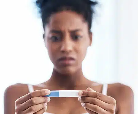 woman looking at a pregnancy test facing an unplanned pregnancy