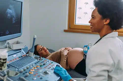 Pregnant woman having an ultrasound done by an ultrasound tech