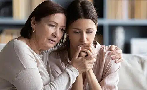 Loving middle aged mother hugging comforting adult daughter 