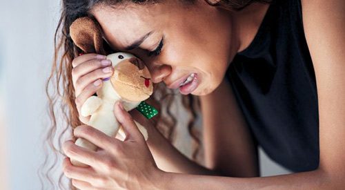 Grieving mother clutches a toy meant for the baby she lost