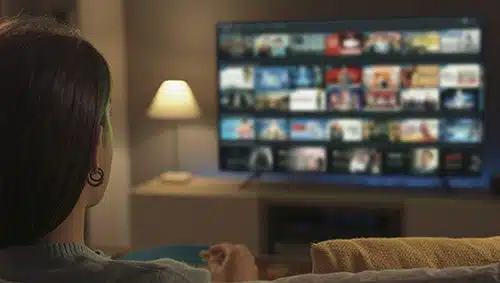 Woman eating popcorn while she browses for adoption movies to stream