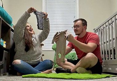 Hopeful adoptive parents Blake and Jacob fold baby clothes in their future child's nursery