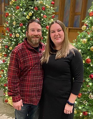 Scott and Wittne pose by Christmas trees at their church