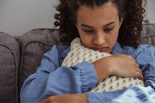 unhappy teenage girl who is pregnant at 15 hugs her pillow 