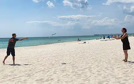 Dan and Kelly tossing a frisbee at the beach