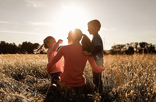 Mother and her children relaxing in a grassy field