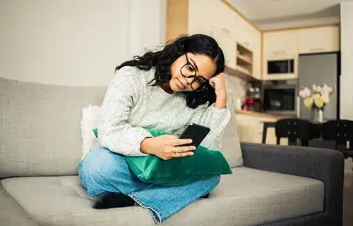 Girl texting with her parents from her sofa