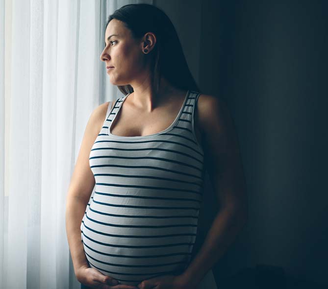 pregnant woman is looking out window