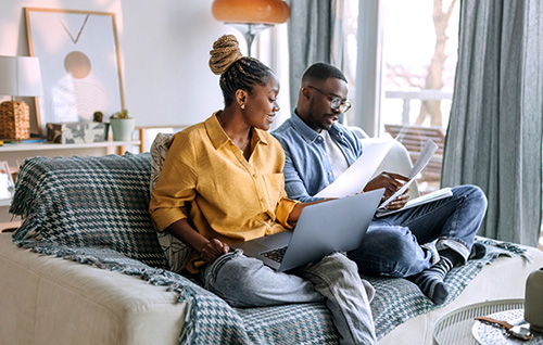 Happy African American couple in their living room, sharing what they've learned about their top picks in adoption agencies