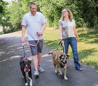 Al and Laura taking their two dogs on a walk