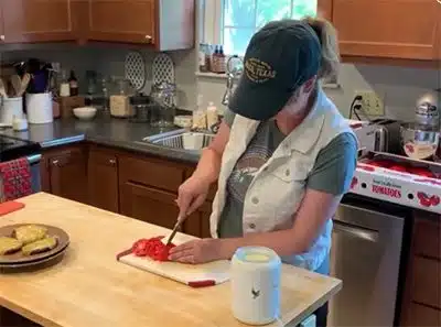 Hopeful adoptive mother Laura cutting tomatoes in her kitchen